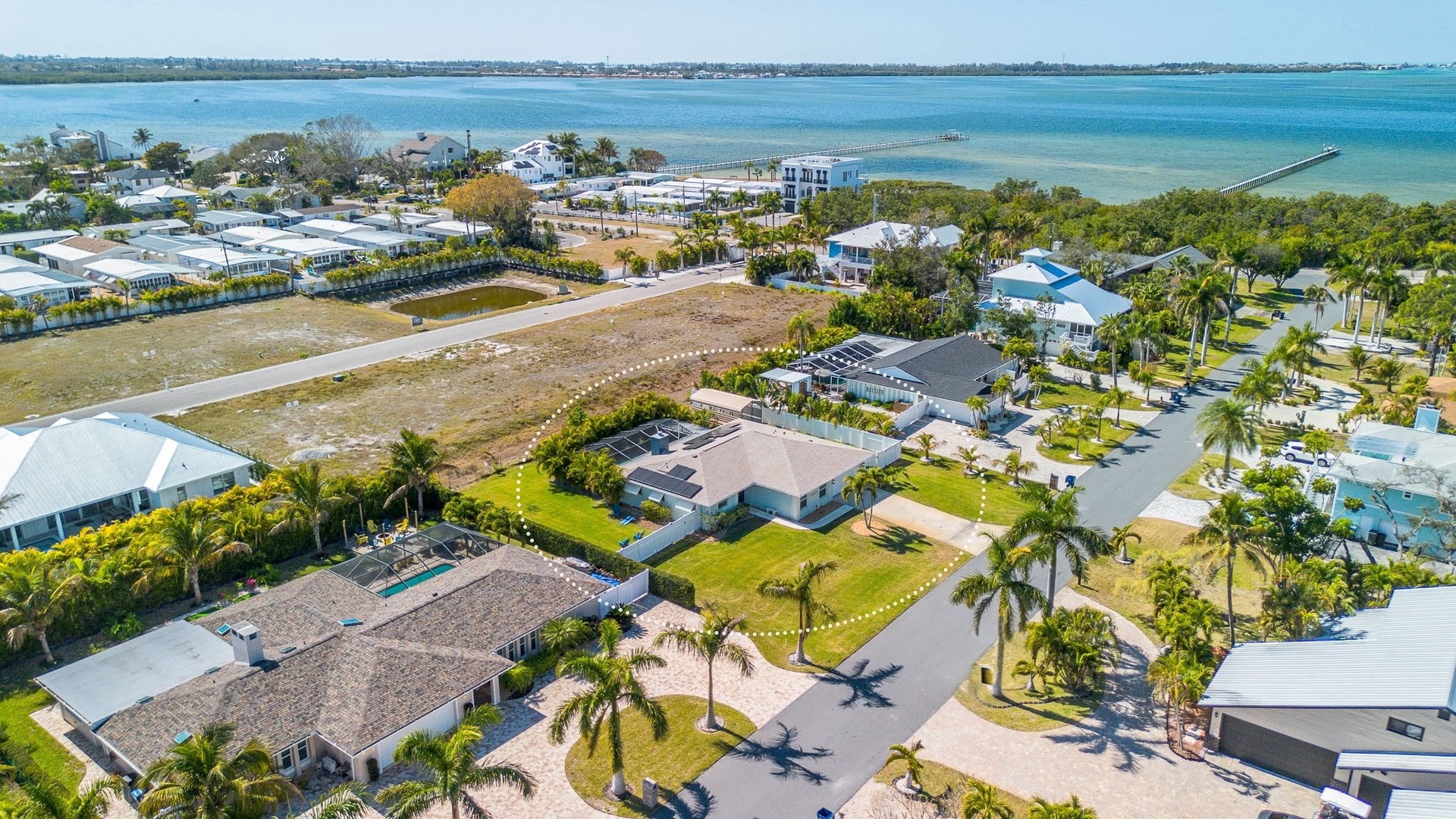Aerial view of charming neighborhood with pristine bay views and manatee watching close by at Portosueno Park.