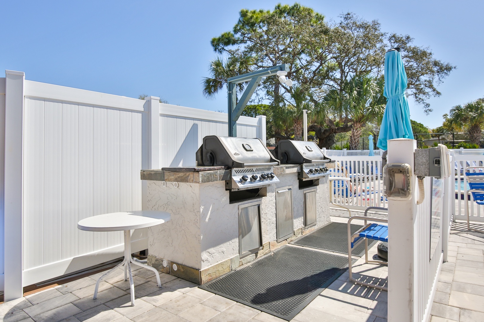 Fire up the grills for your perfect poolside barbecue! Two premium gas grills await your culinary creations in this sunny outdoor kitchen area.