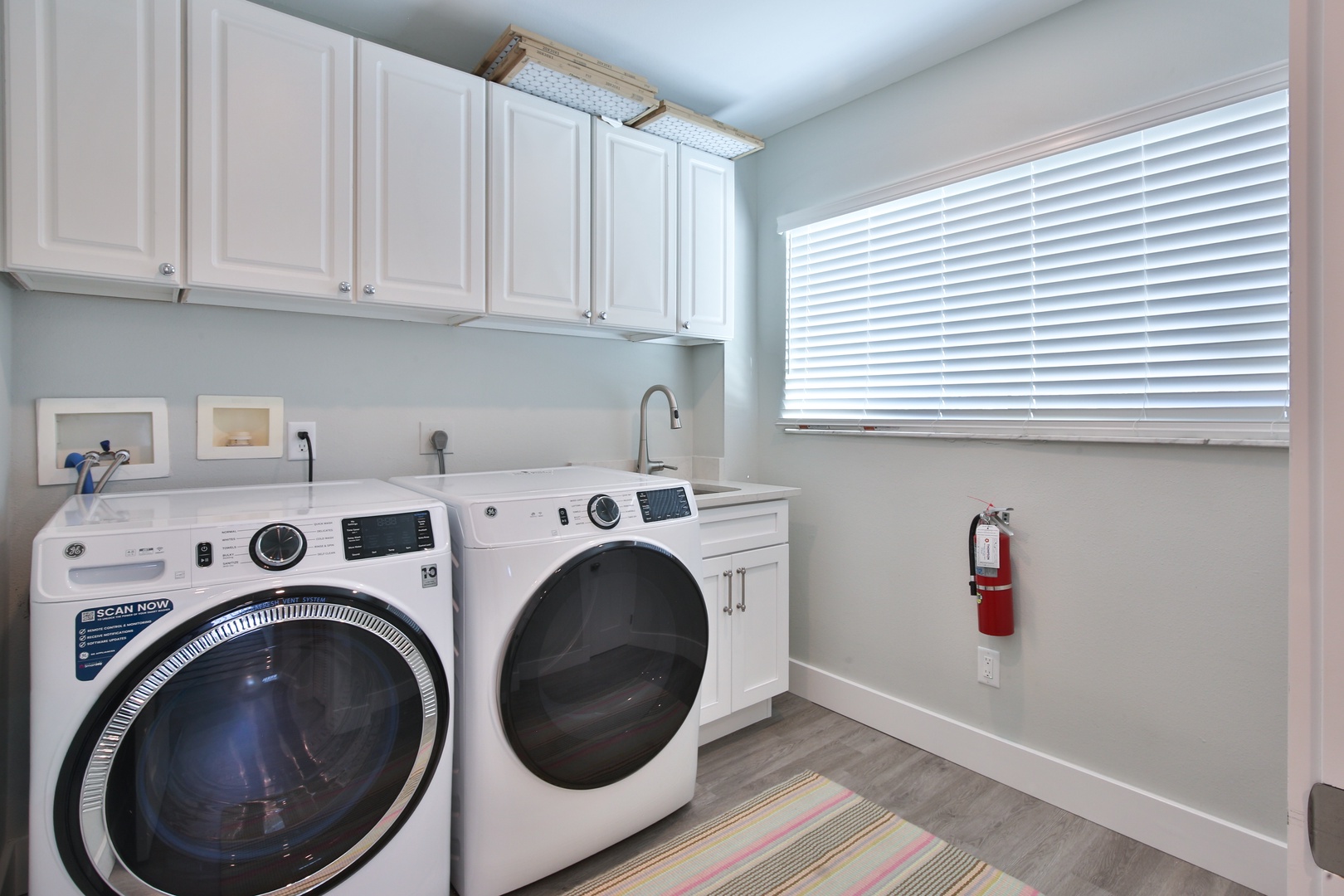 Your fully equipped laundry room features modern washer and dryer with ample cabinet storage for hassle-free stays.