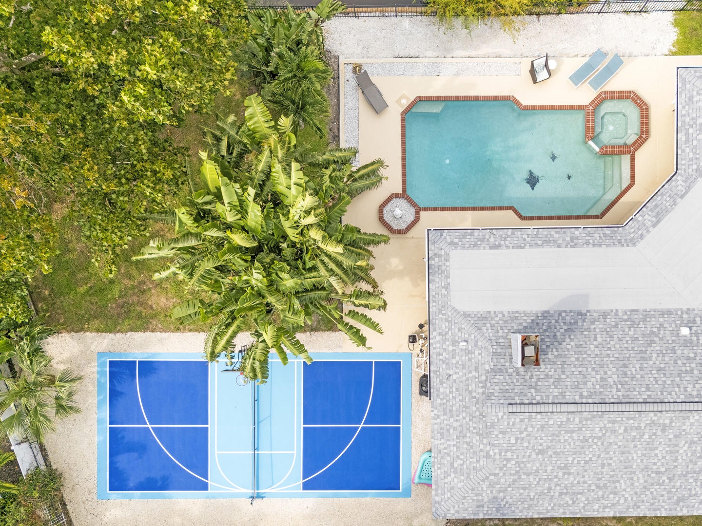 The property offers a refreshing swimming pool and a versatile outdoor sports court, nestled among lush tropical greenery for an active, relaxing getaway.