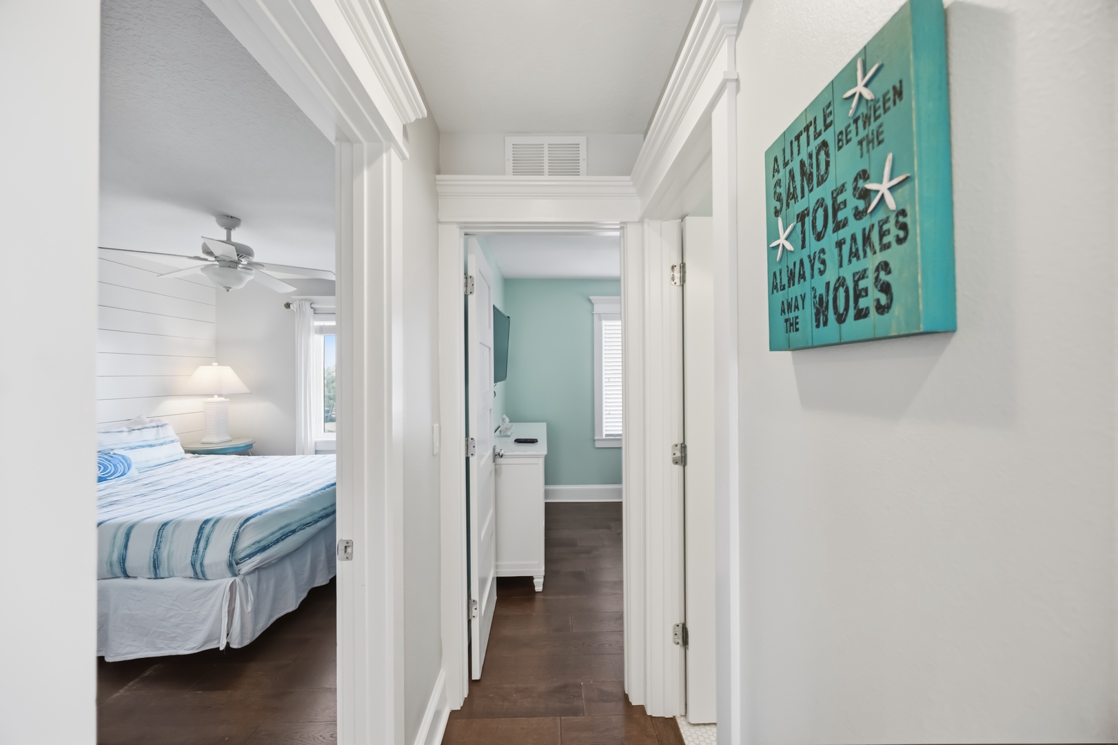 Your peaceful hallway connects the coastal-themed bedroom to your private bathroom, with charming beach decor welcoming you home.