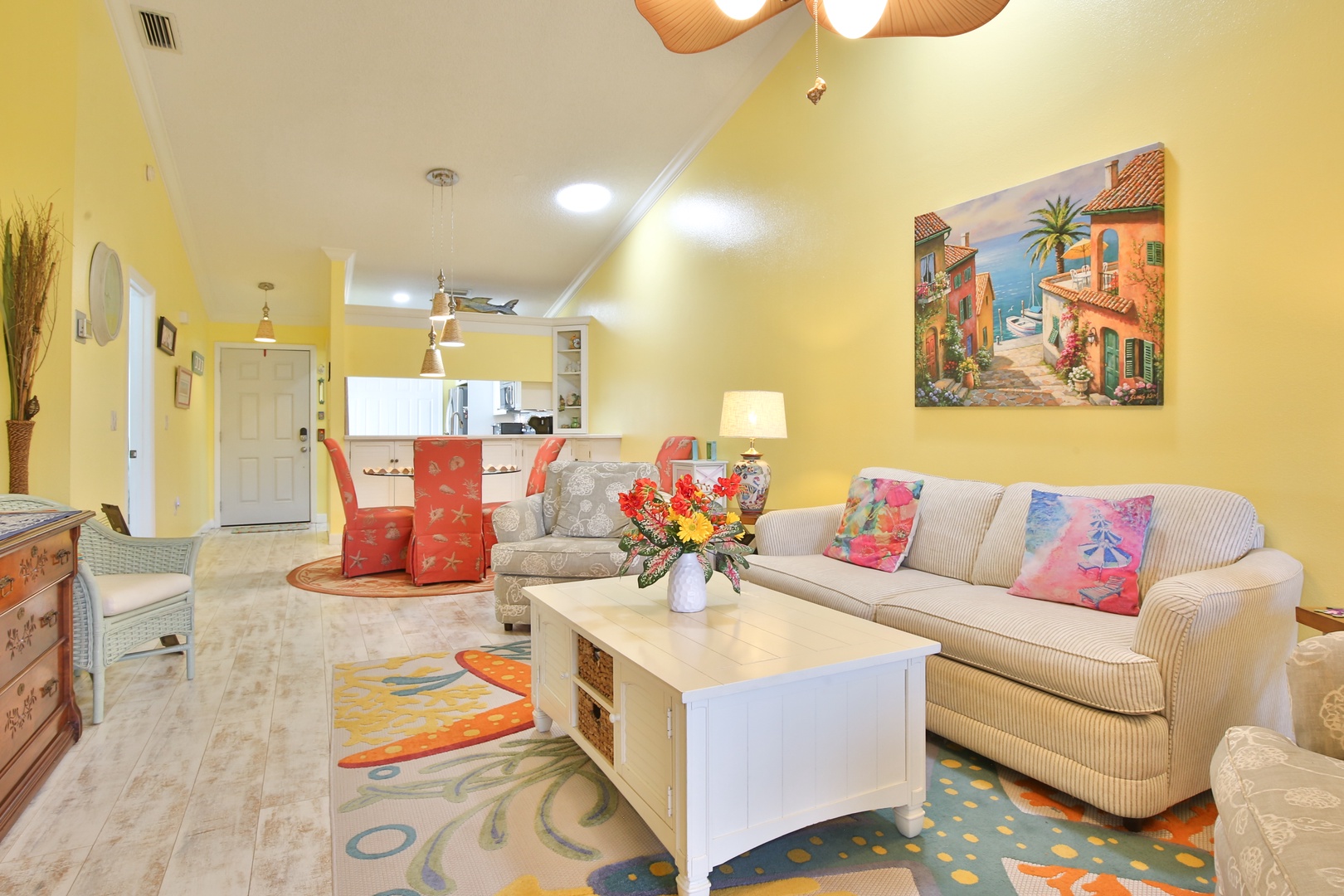 You'll love gathering in this sunny living space, where coastal art, cheerful colors, and plush seating invite you to relax and unwind after exploring.