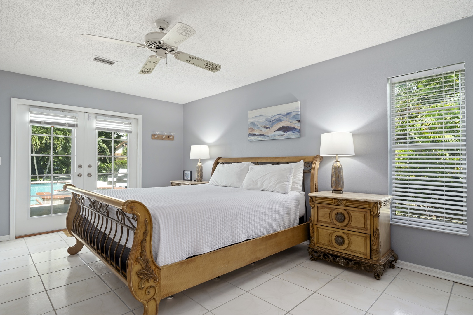 Drift off in your tranquil bedroom, where soft gray walls and bright windows invite a restful escape. Step through the glass door to your private pool just outside.
