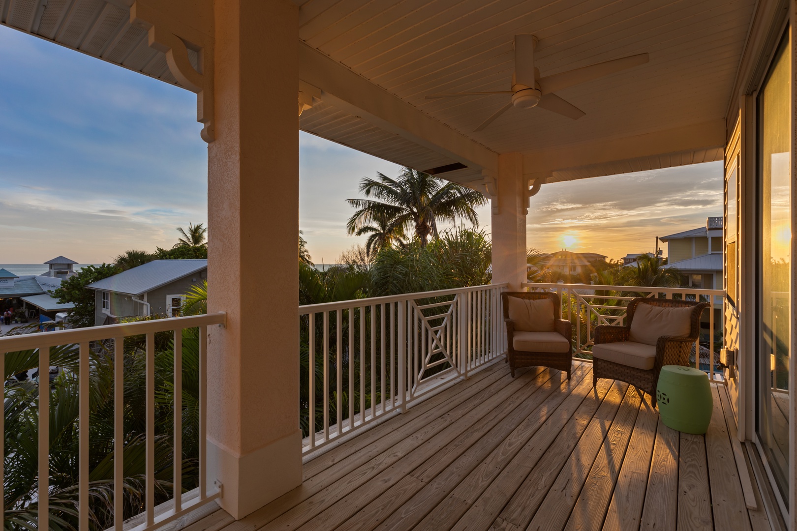 Unwind on your private balcony with comfortable seating as tropical sunsets paint the sky in golden hues over palm trees.