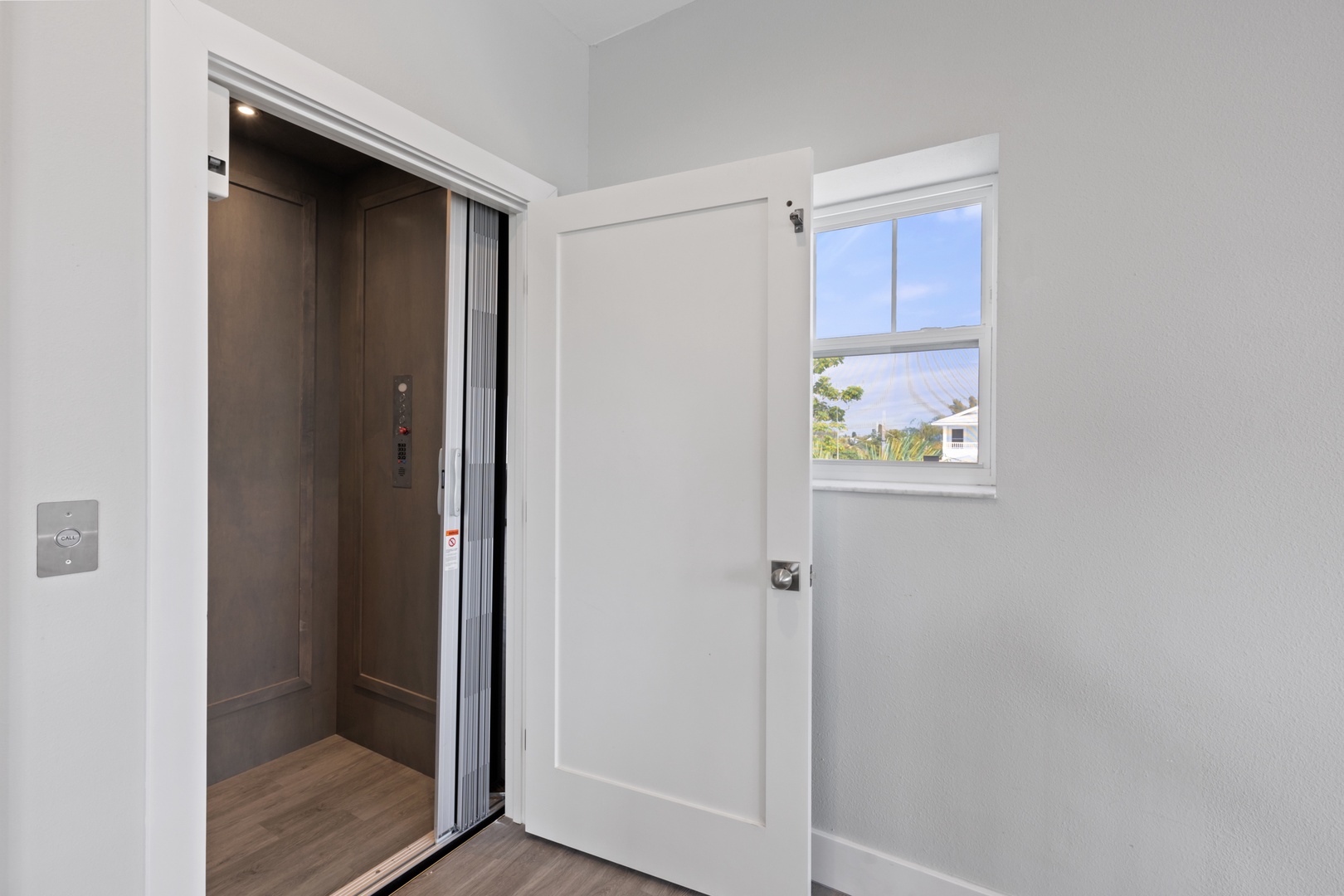 Step into your modern elevator access with natural light streaming through the window, creating a bright and welcoming arrival experience.