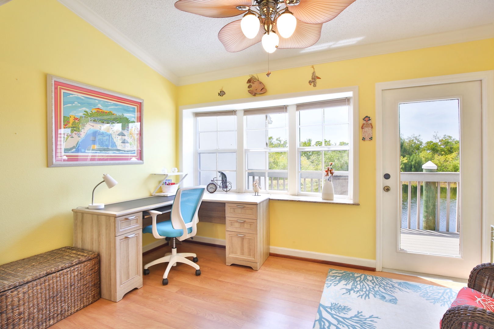 Your bright workspace overlooks the waterfront, perfect for catching up on emails while soaking in serene views through the balcony door and windows.