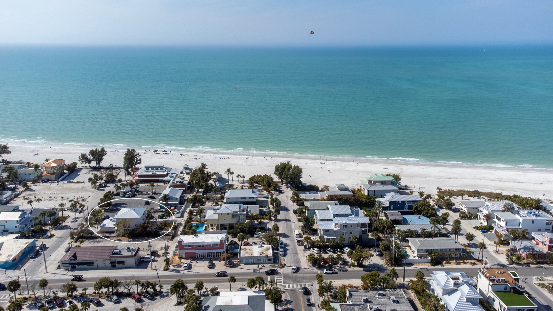 Beachfront community with pristine sandy shores and turquoise waters just steps from residential properties.