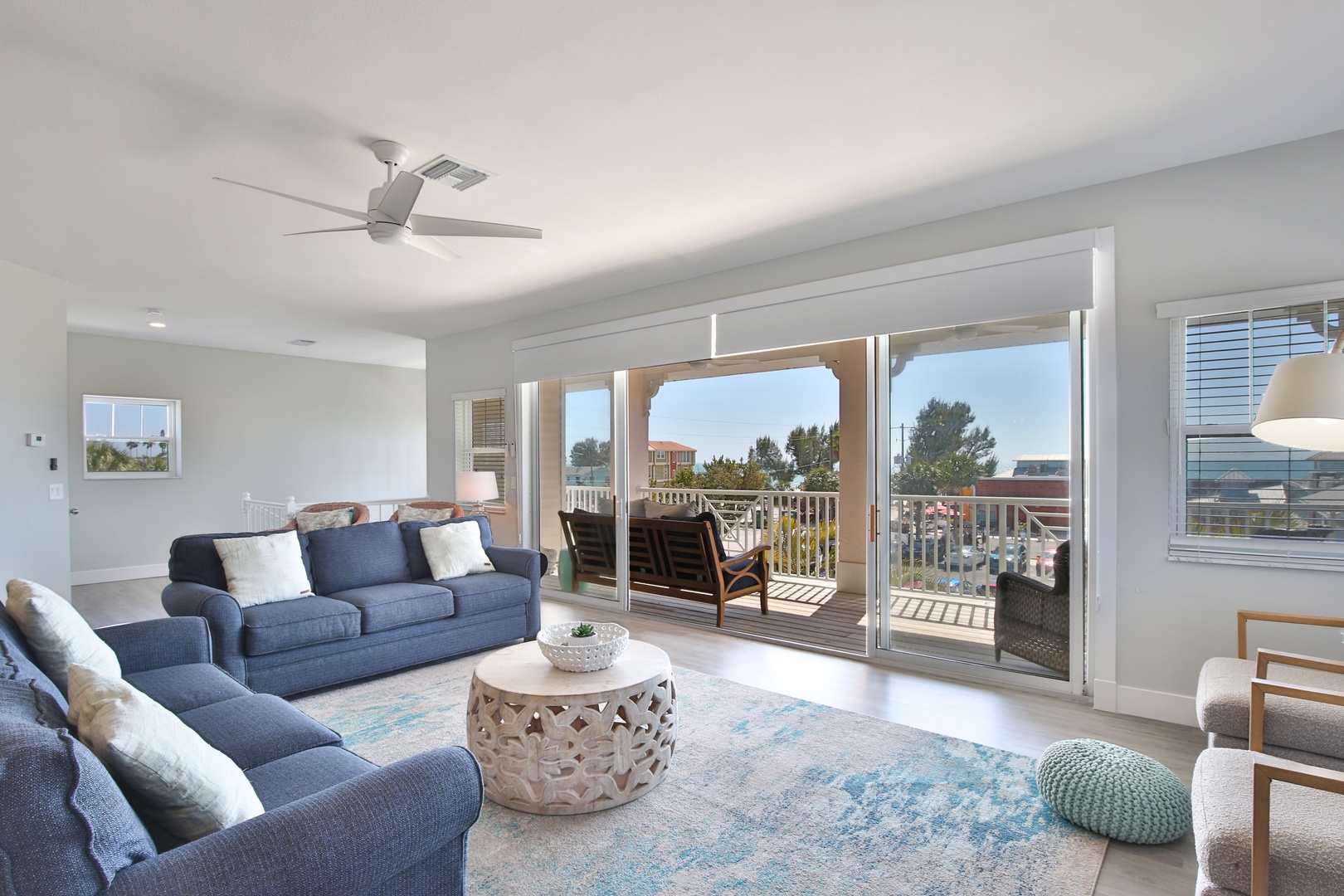 Relax in your bright living room with plush seating and stunning balcony views through floor-to-ceiling windows.