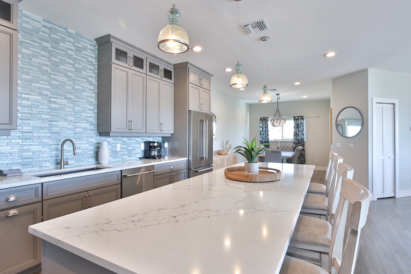 You'll love creating meals in this stunning chef's kitchen with marble counters, modern appliances, and stylish pendant lighting.