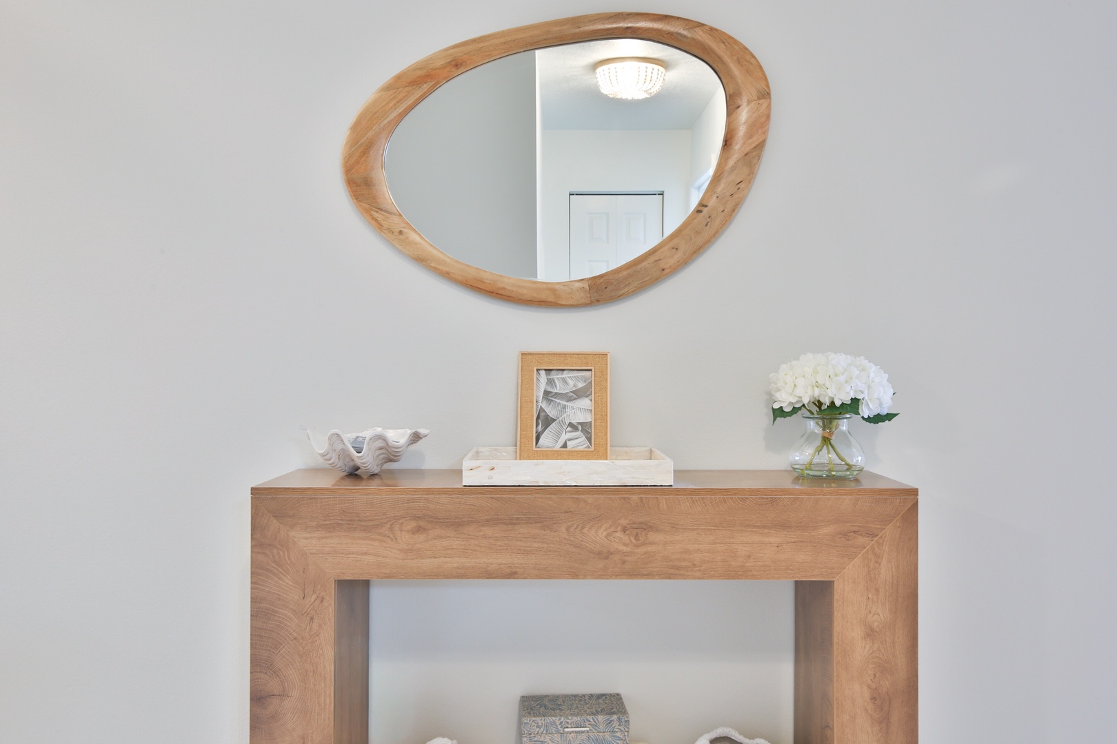 Step into your stylish entryway where warm wood tones and fresh blooms create the perfect welcome home feeling.