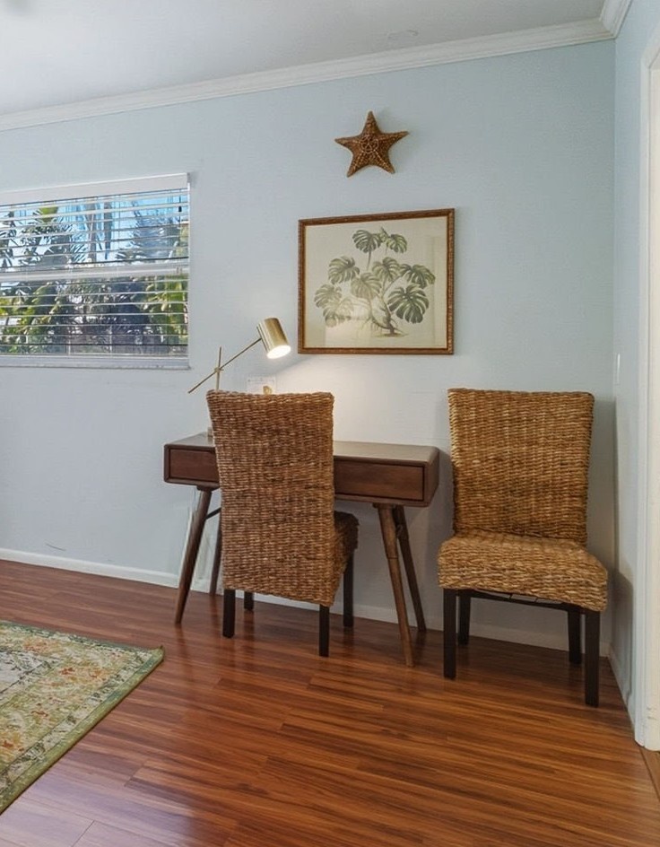 You'll love this charming workspace corner with its tropical vibes and wicker chairs - perfect for morning coffee or catching up on emails.