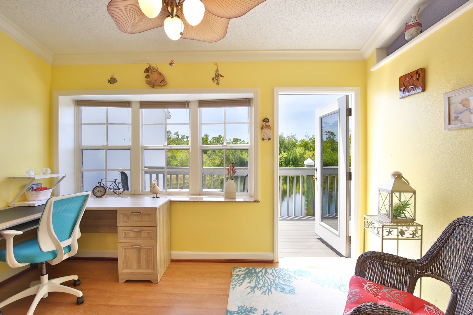 Sunshine-yellow walls and bright tropical accents set a cheerful tone in your private workspace, where large windows and direct balcony access let you enjoy treetop views and warm breezes year-round.