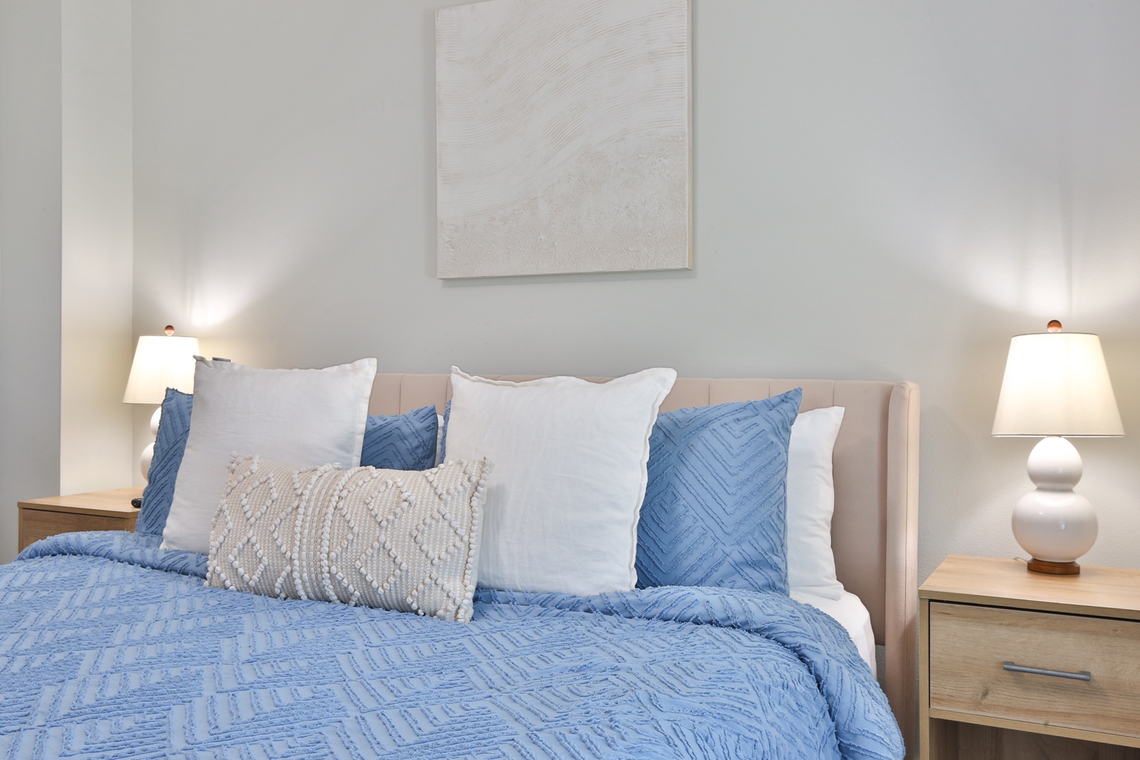 Drift into peaceful sleep in your tranquil bedroom, where soft blue linens and warm bedside lighting create the perfect sanctuary for rest.