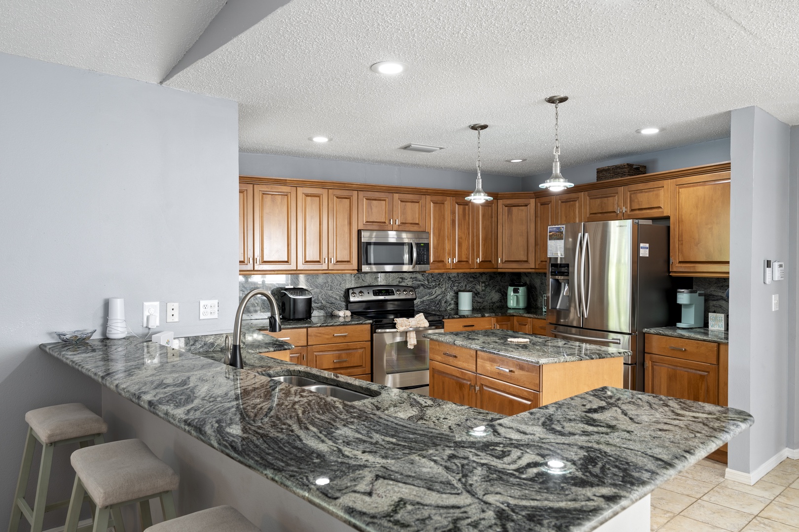Your spacious gourmet kitchen invites you to create memorable meals with gleaming granite countertops, warm wood cabinetry, and modern stainless appliances throughout.