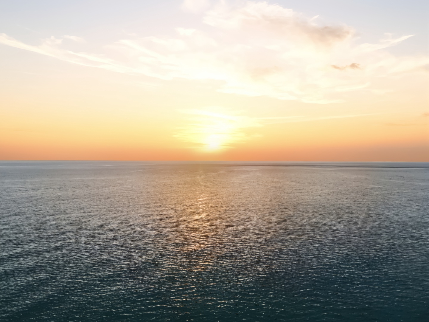 Golden sunset paints the ocean horizon in warm hues, creating a breathtaking evening display over endless waters.