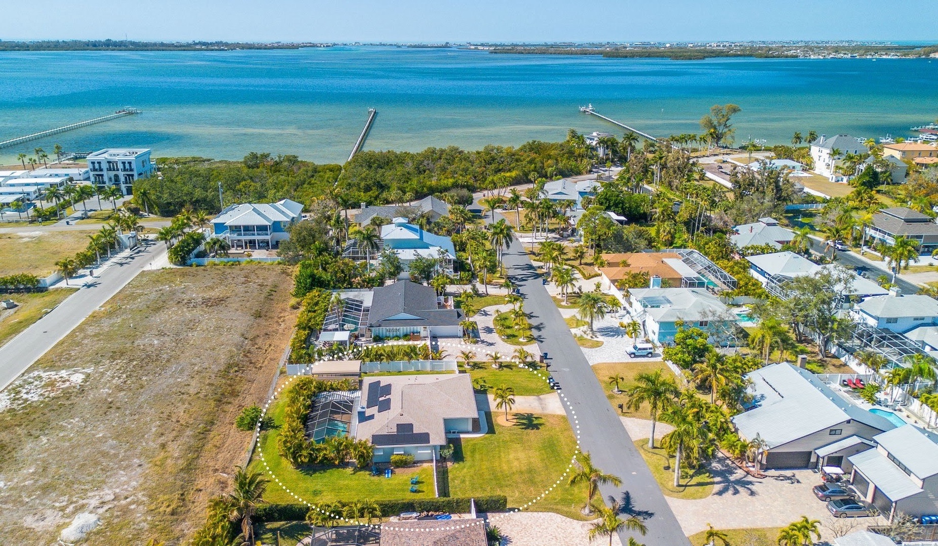 Aerial view of charming neighborhood with pristine bay views and manatee watching close by at Portosueno Park.