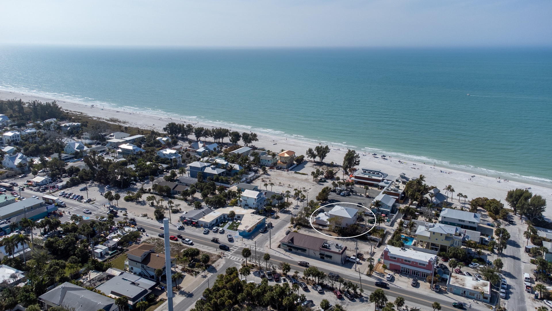 Coastal community overlooking pristine white sand beach and turquoise waters with convenient nearby amenities and beachfront access.