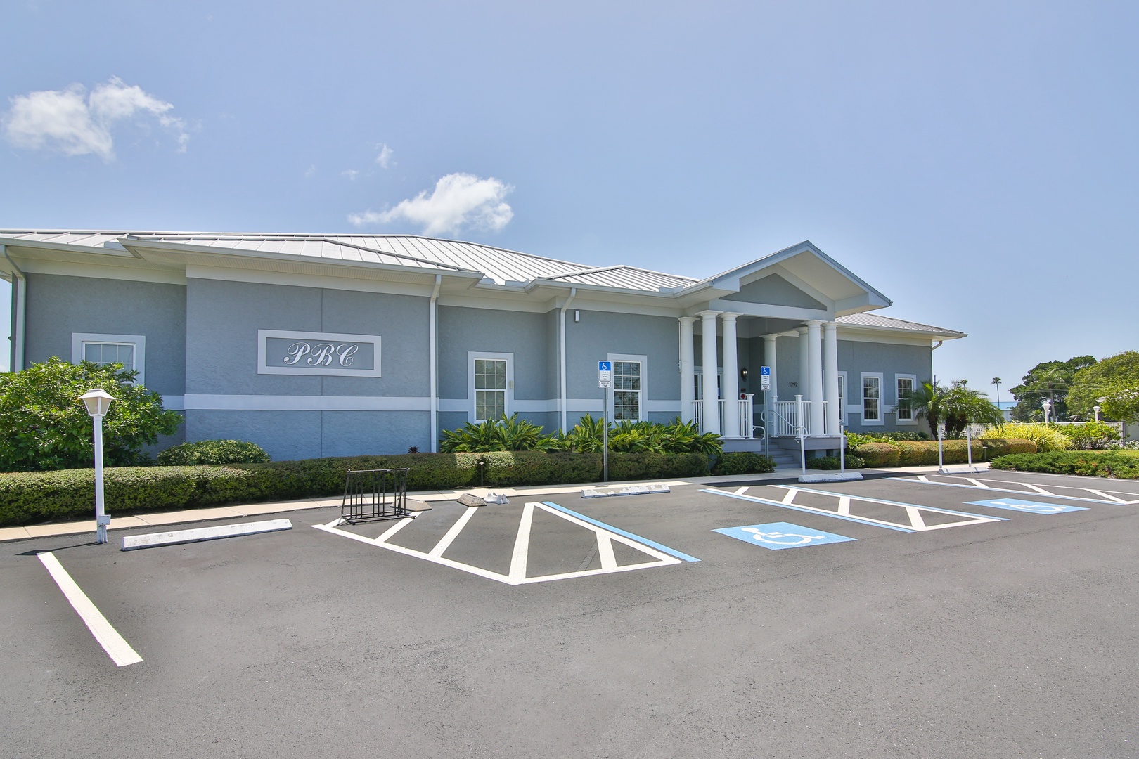 Property building with easy parking access and accessible spaces, surrounded by tropical landscaping and lush greenery.