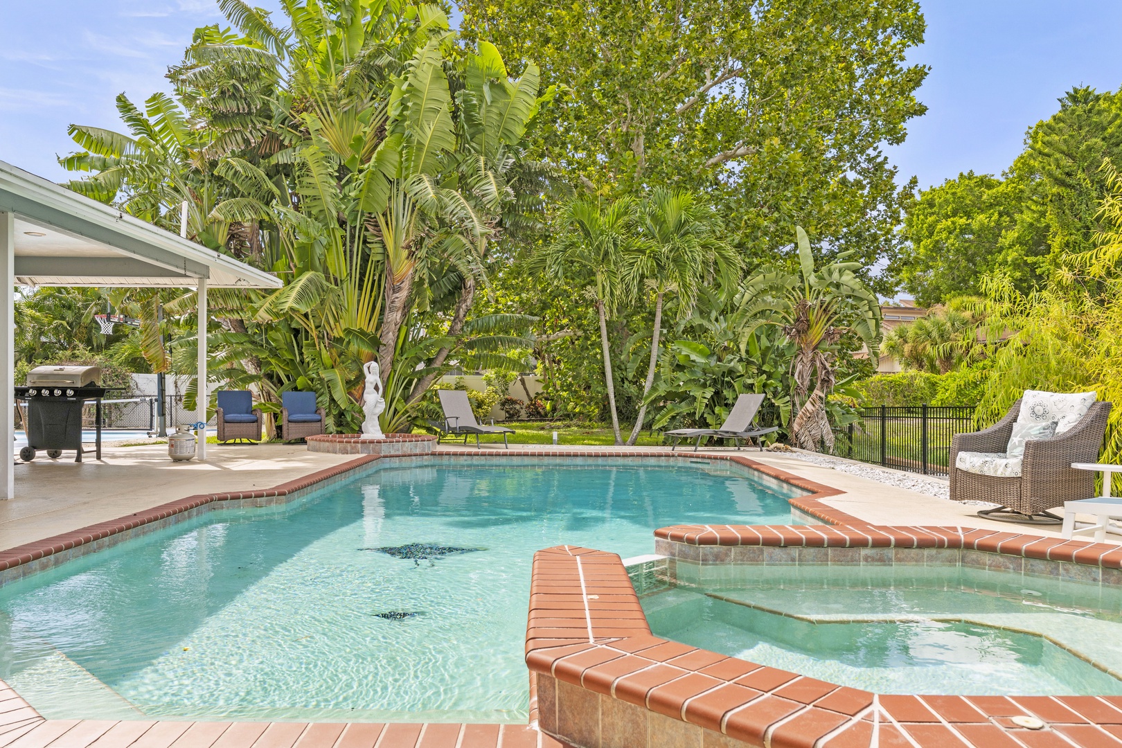 A serene private pool surrounded by lush tropical landscaping and comfortable lounge seating—your perfect escape for sunny days and warm evenings.