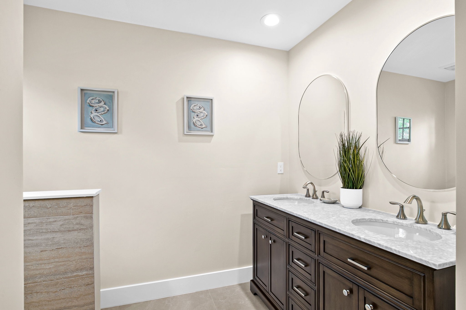 Unwind in your elegant bathroom featuring dual vanities, marble countertops, and a serene coastal vibe that makes your daily routine feel luxurious.
