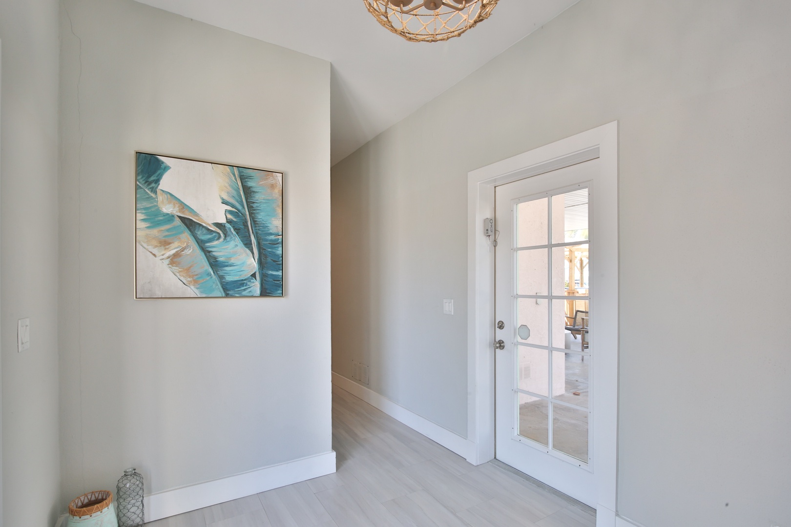 Step into your stylish entryway where coastal artwork and modern lighting create a welcoming first impression of your vacation retreat.