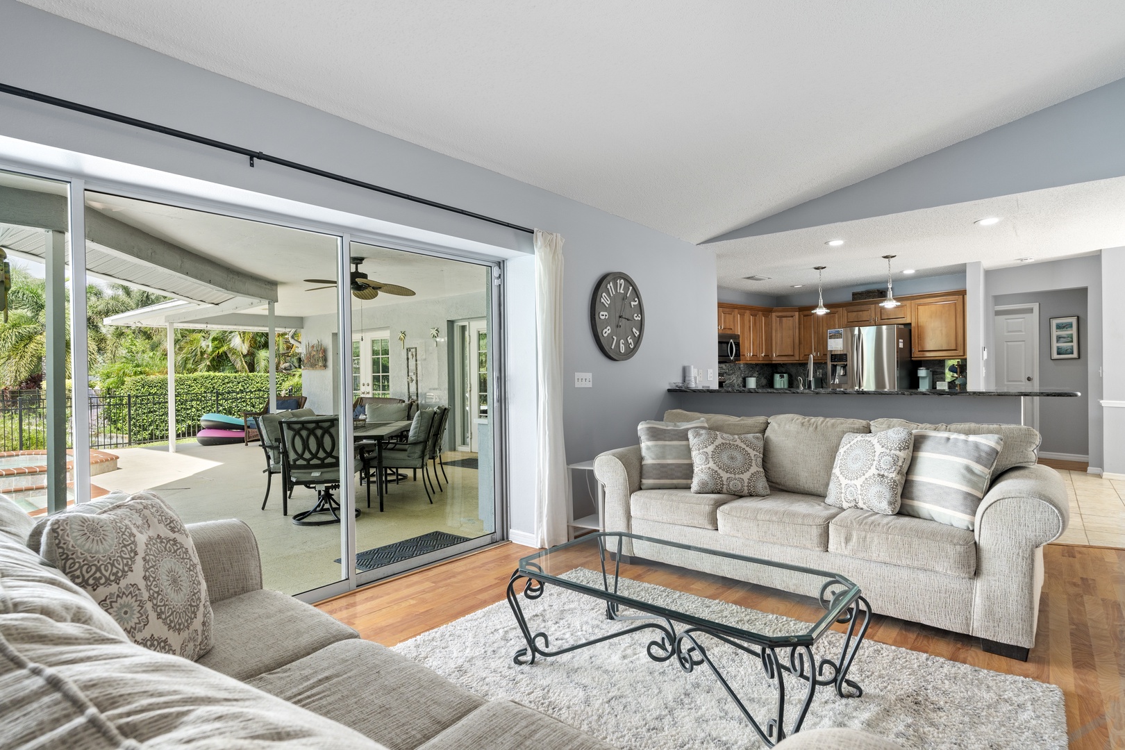 Sink into plush couches in your bright, open living space that flows seamlessly to the kitchen and out to your private covered patio with a sparkling pool beyond.