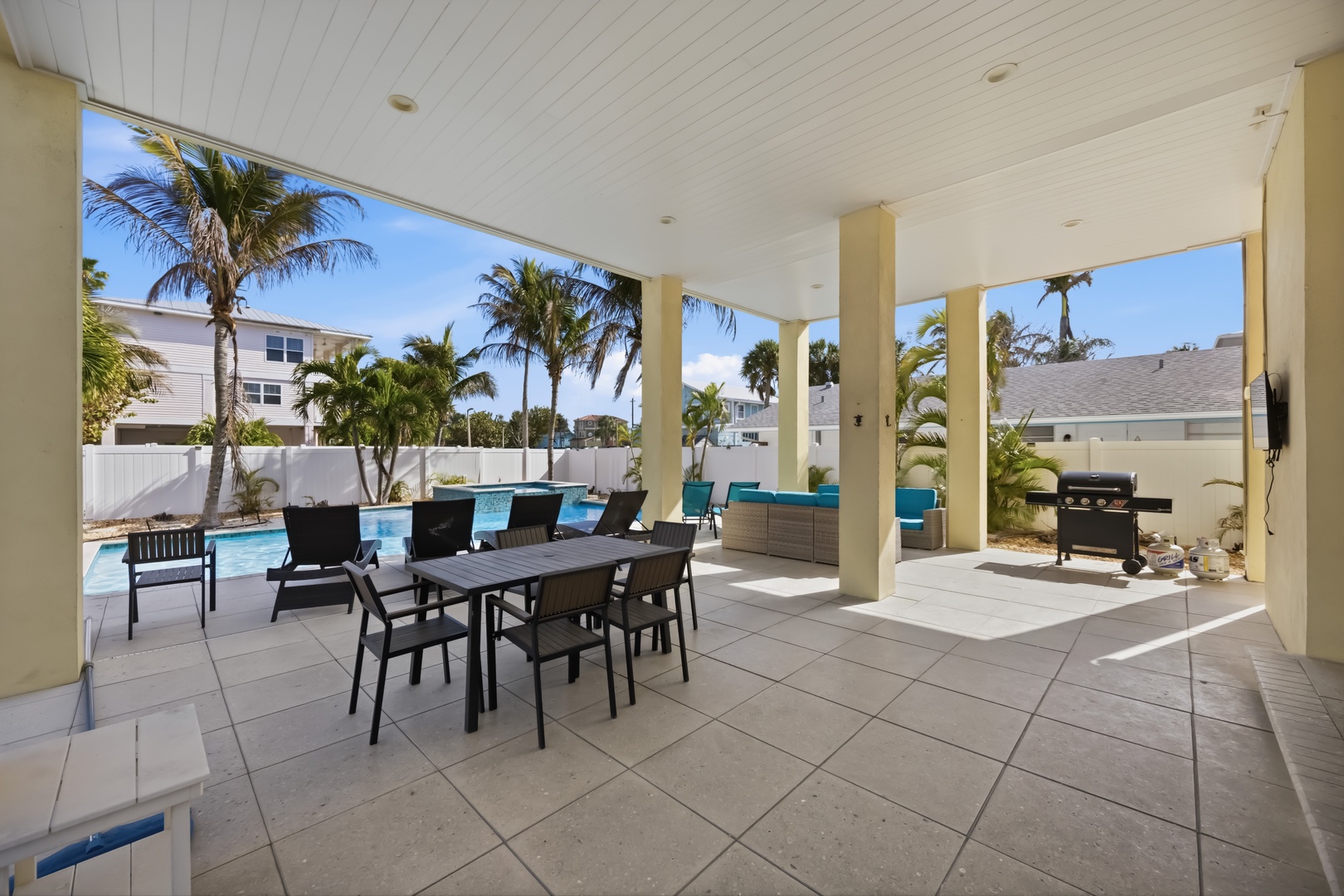 Your covered patio opens to a sparkling pool surrounded by swaying palms, perfect for dining al fresco and grilling under sunny Florida skies.