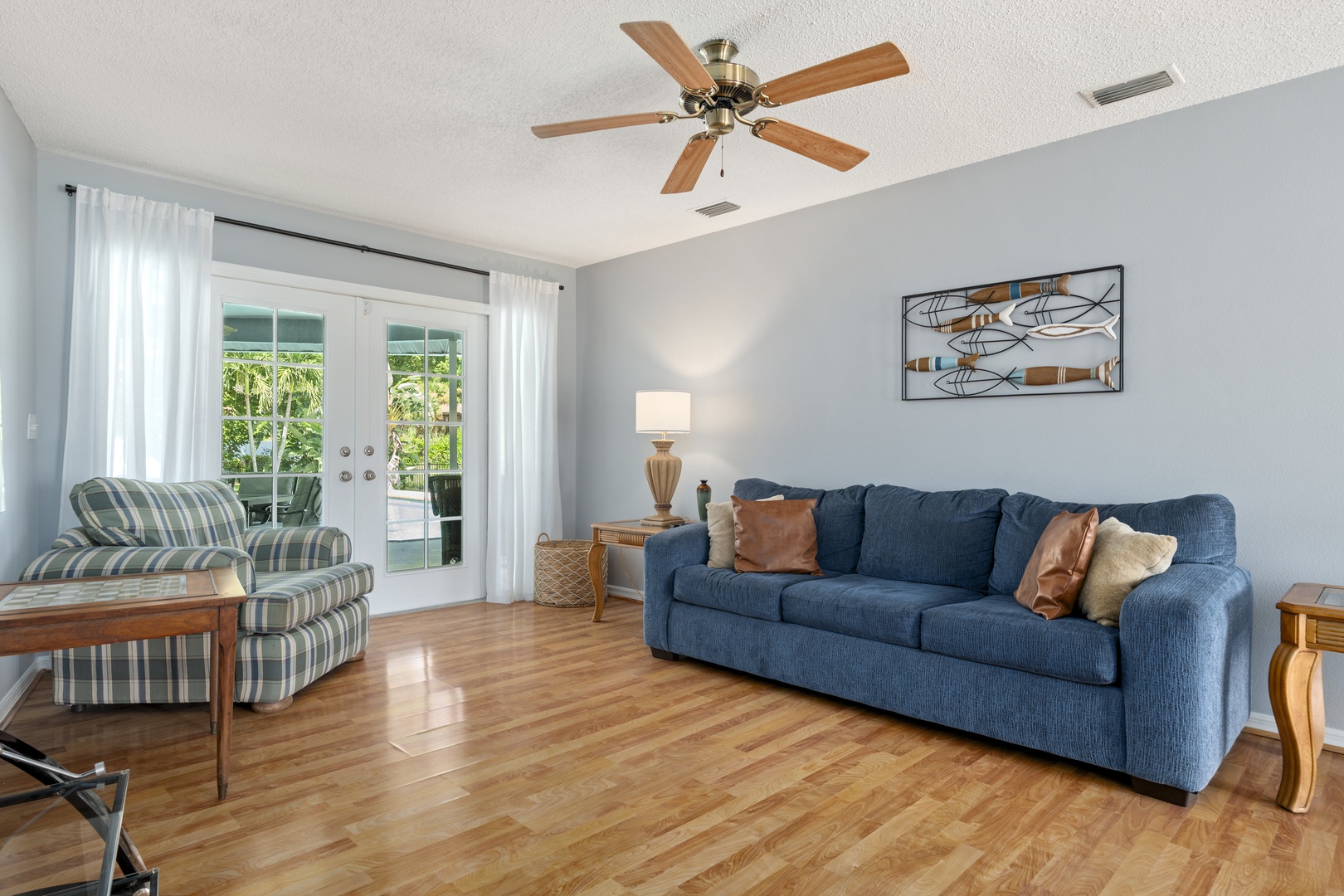 Unwind in your spacious living room, cooled by ceiling fans and flooded with natural light. Step outside through the glass doors to enjoy your private outdoor space any time.