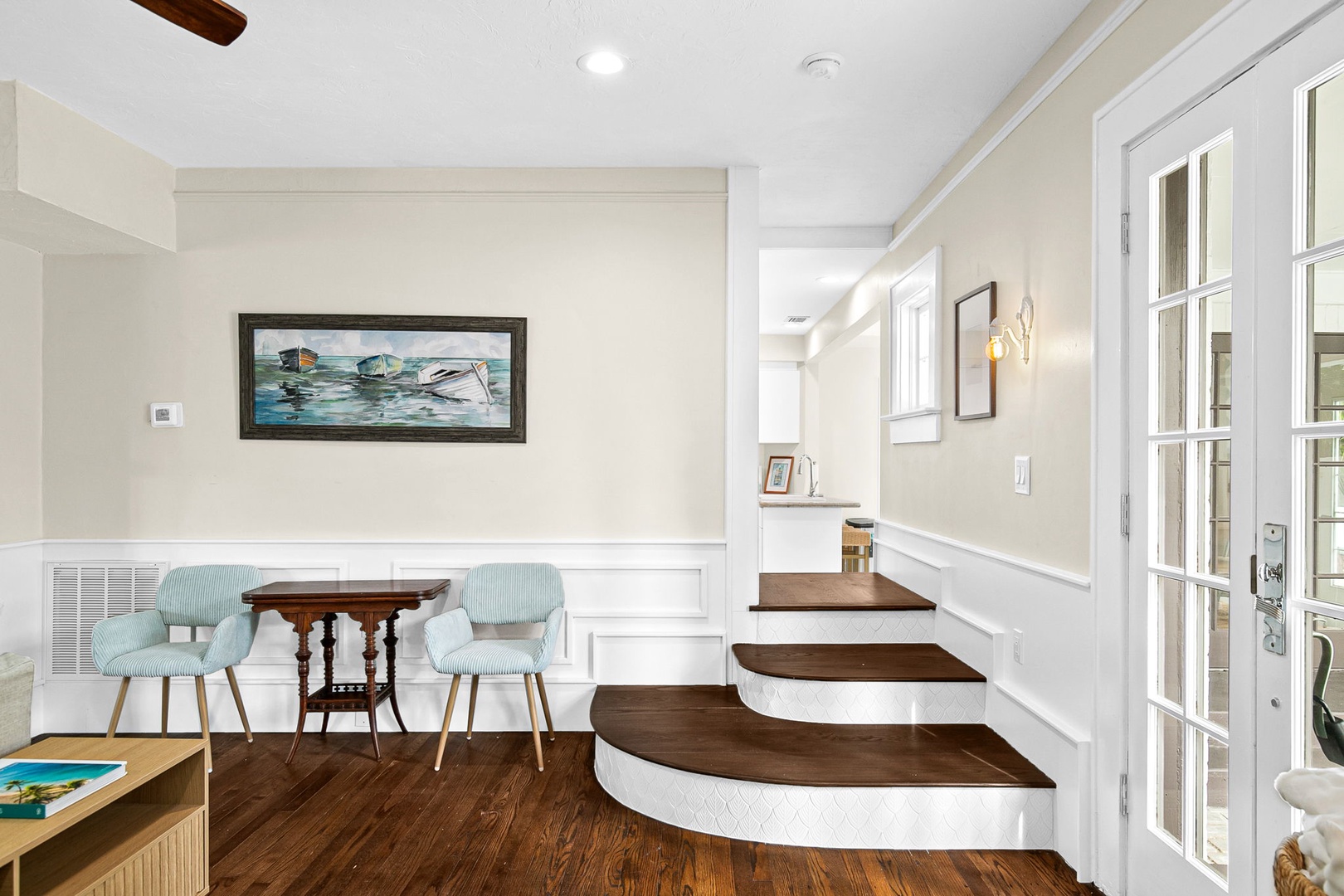 Your charming dining nook features mint green chairs and rich hardwood floors, perfect for intimate meals together.