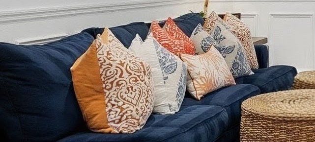 Sink into this plush navy sofa adorned with colorful pillows, perfect for unwinding after your adventures.