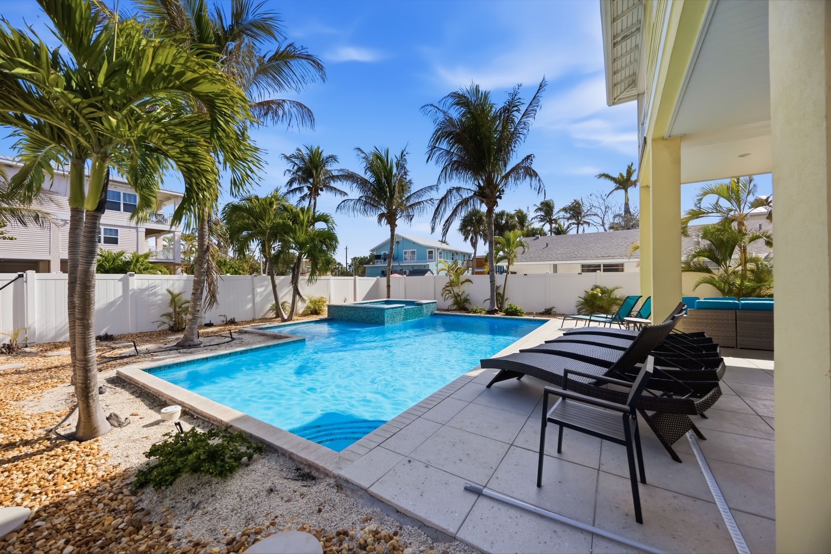 Your private tropical oasis awaits with a sparkling pool surrounded by swaying palms and comfortable loungers for ultimate relaxation.