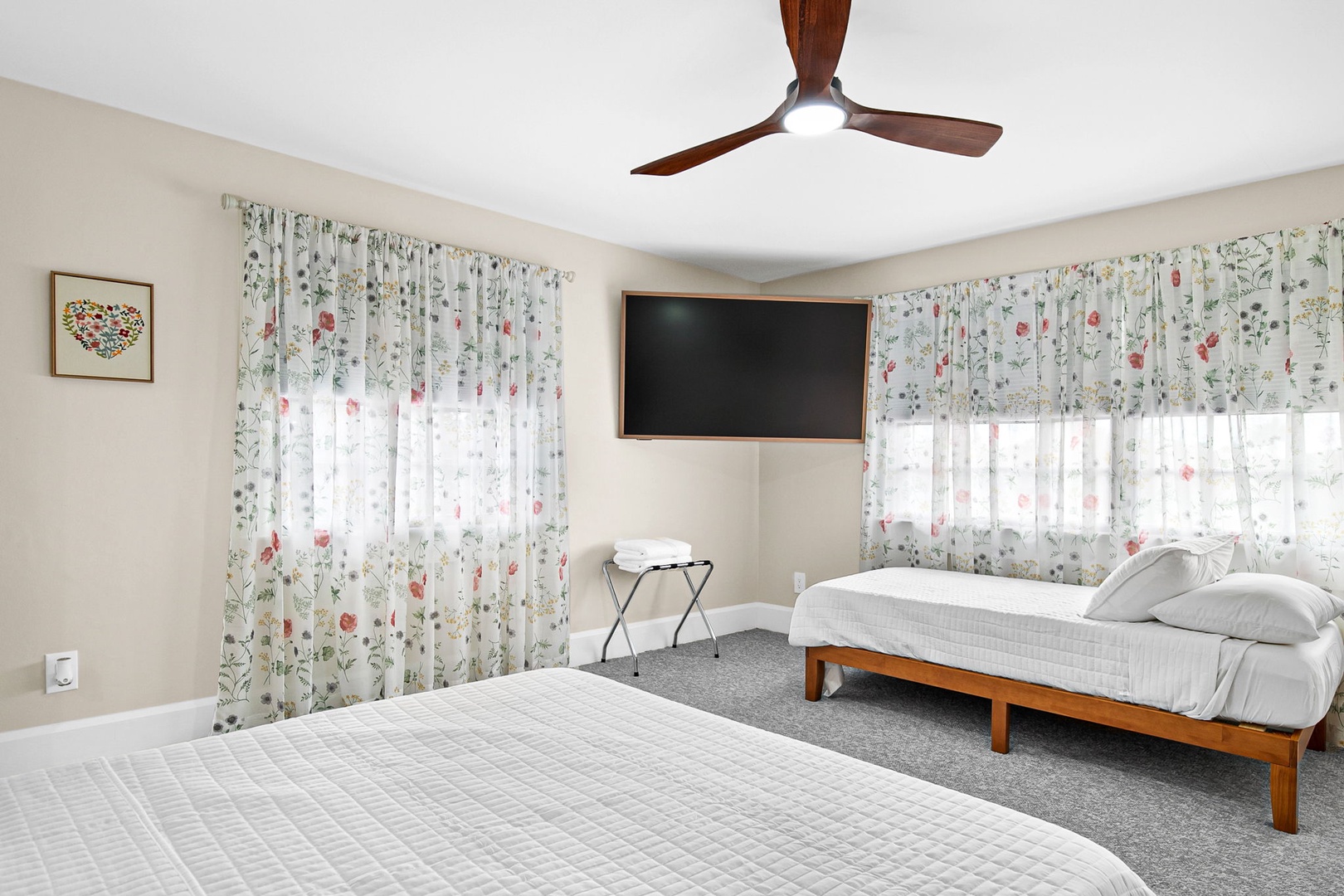 Your bright bedroom features two comfortable beds and charming floral curtains that let in natural light.