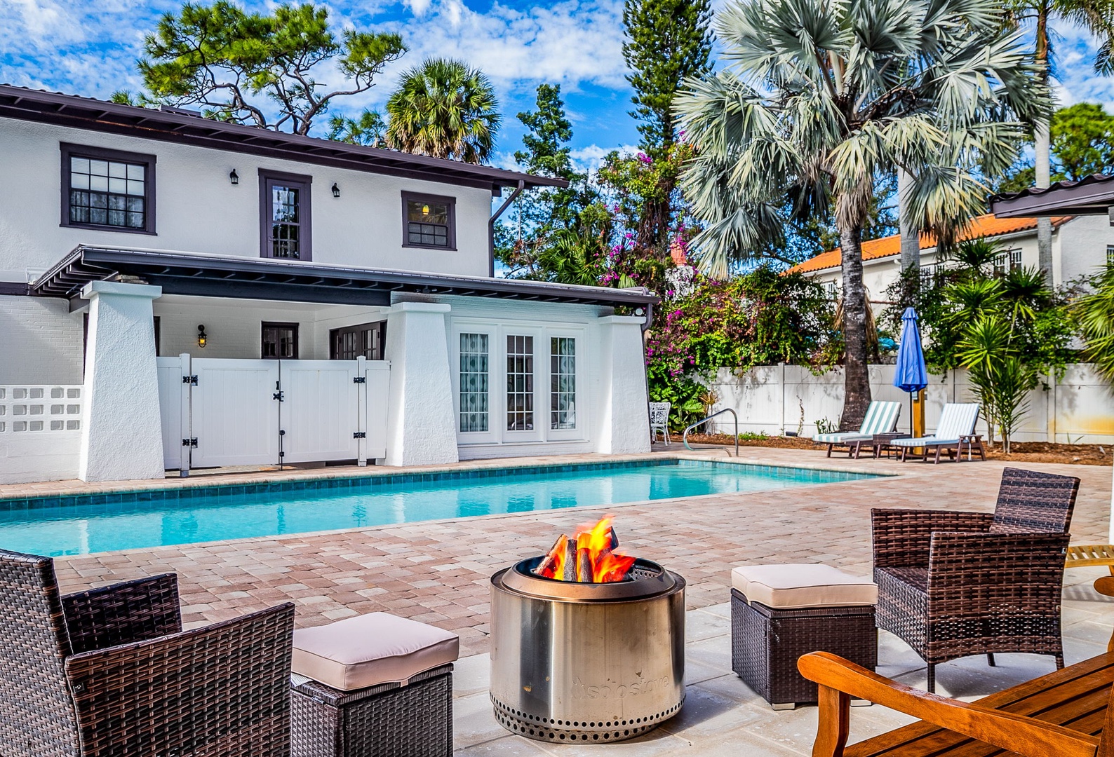 Gather around your private fire pit while the pool sparkles nearby, surrounded by swaying palms in this tropical paradise.