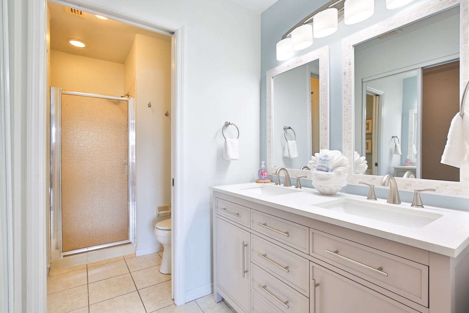 Your spacious bathroom features dual vanities and a separate glass-enclosed shower for your comfort.