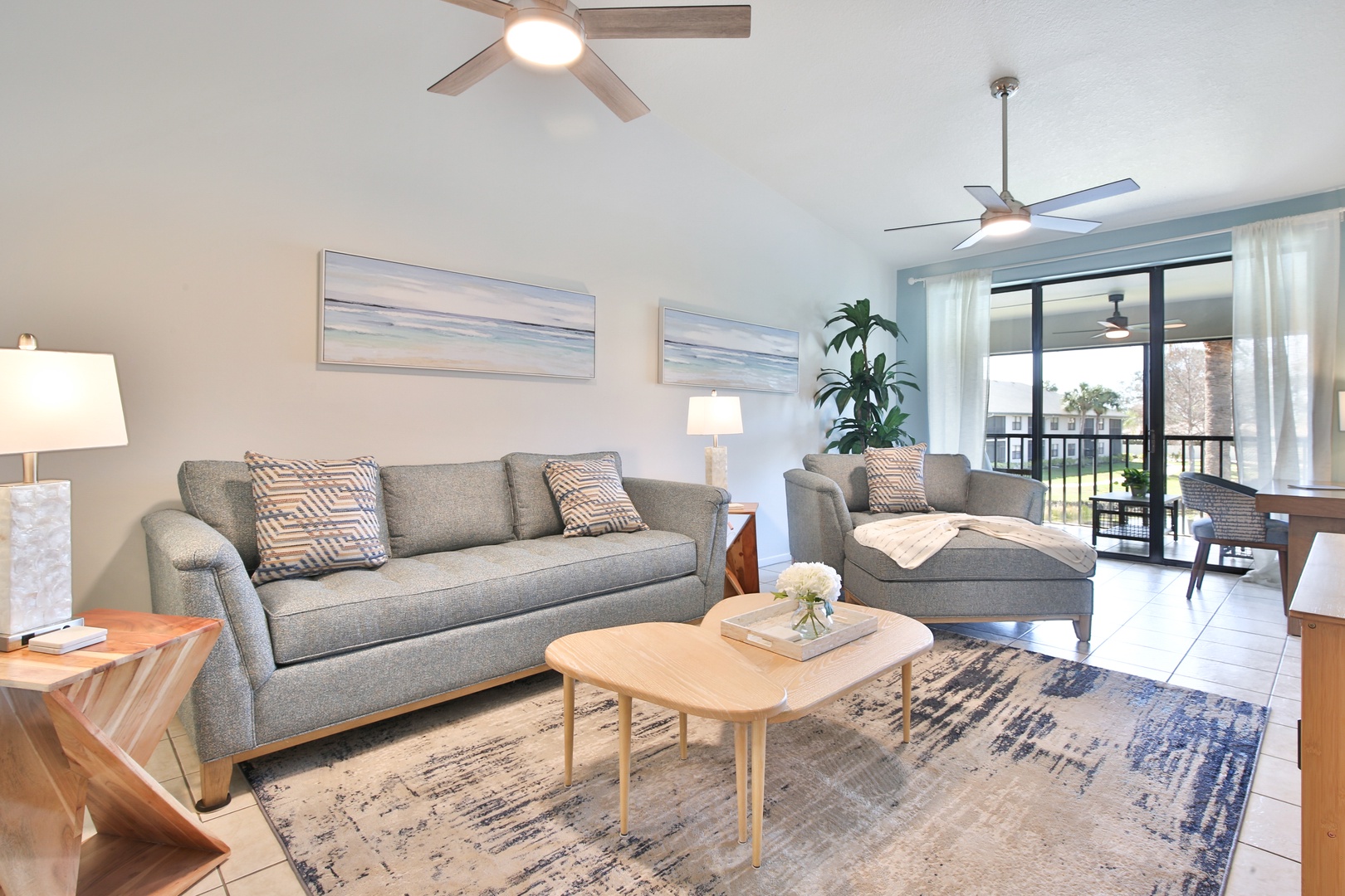 Relax in your spacious living area with comfortable seating and natural light streaming through the balcony doors.