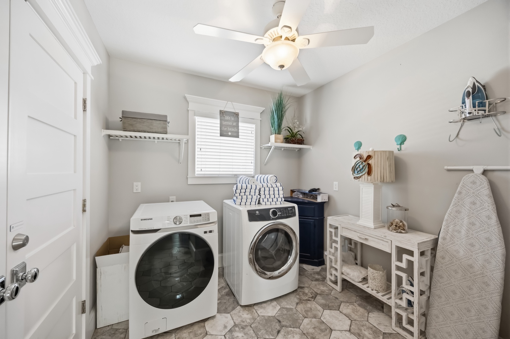 Your bright laundry room features modern appliances and coastal charm, making wash day feel refreshing with plenty of counter space for folding.
