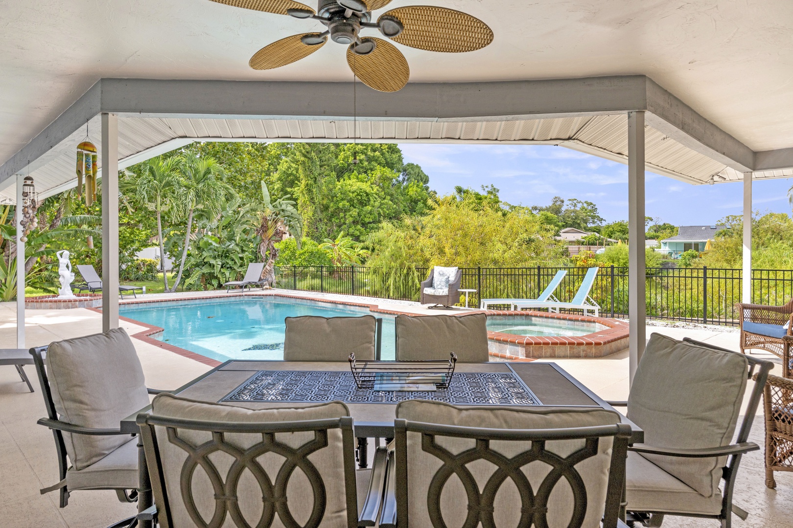 Relax under the covered patio with your morning coffee, gazing out at the sparkling pool and lush garden surroundings that frame your private outdoor retreat.