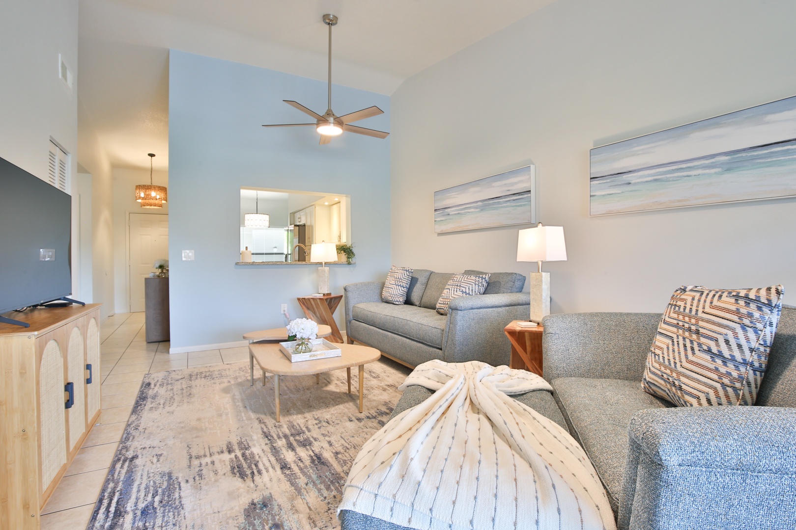 Unwind in your coastal-inspired living room with comfortable seating, ocean artwork, and modern touches creating the perfect retreat.