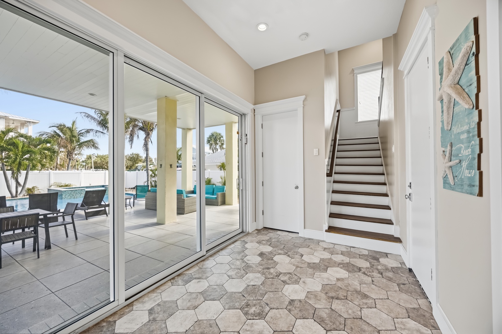 Your bright entryway opens to stunning tropical views and pool area, creating instant vacation vibes.