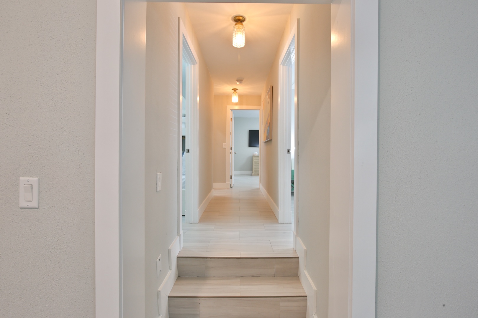 Step into your bright, modern hallway where warm lighting guides you through this thoughtfully designed space.