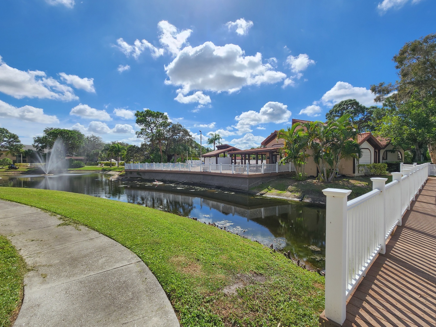 Peaceful waterfront community with fountain views, bridge access, and lush landscaping creating a serene neighborhood setting.