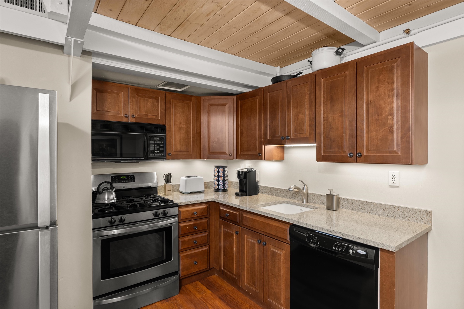 Your fully equipped kitchen features warm wood cabinets, granite counters, and modern appliances for preparing memorable meals during your stay.