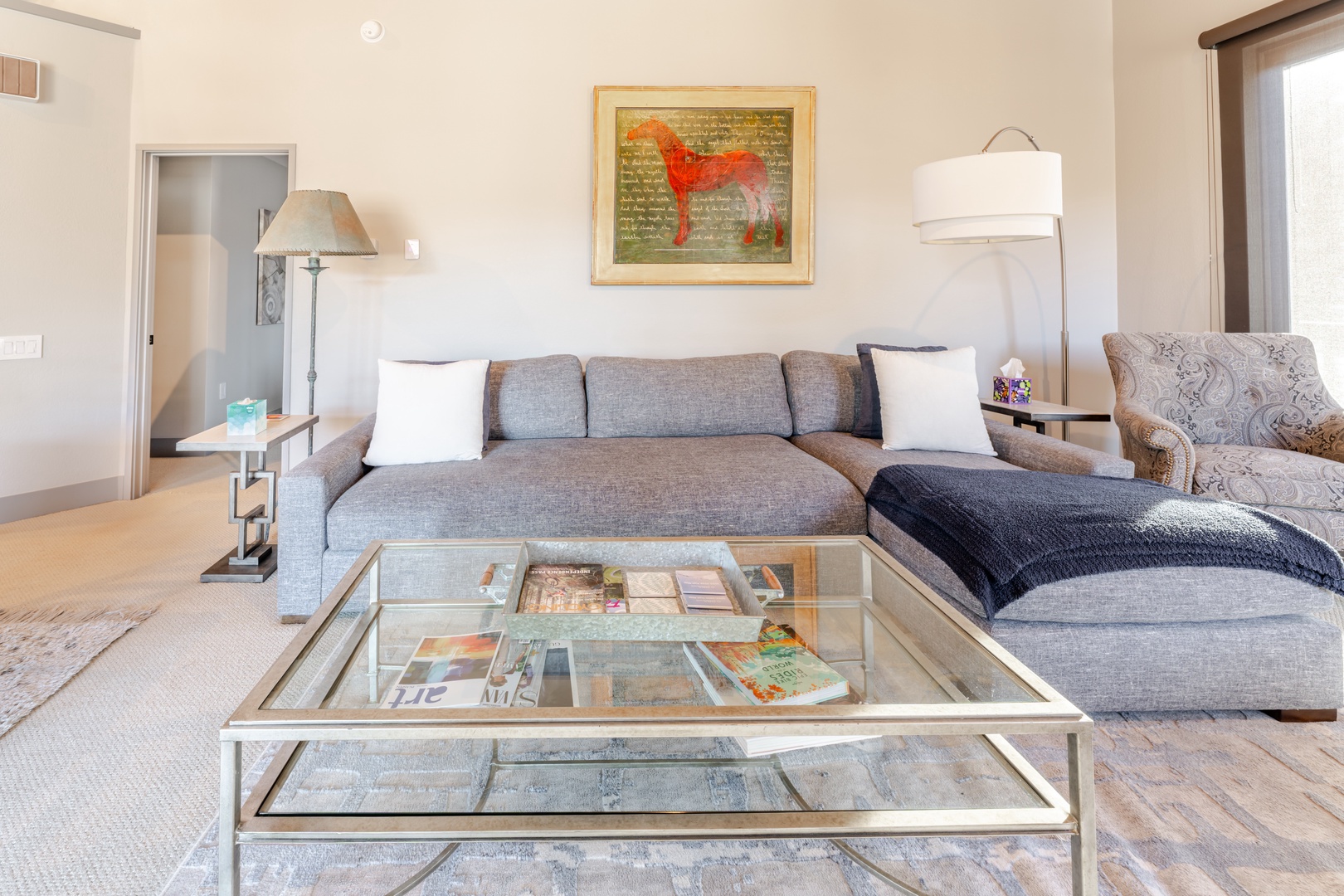 Your bright living room invites relaxation with plush seating, elegant glass coffee table, and thoughtful details.