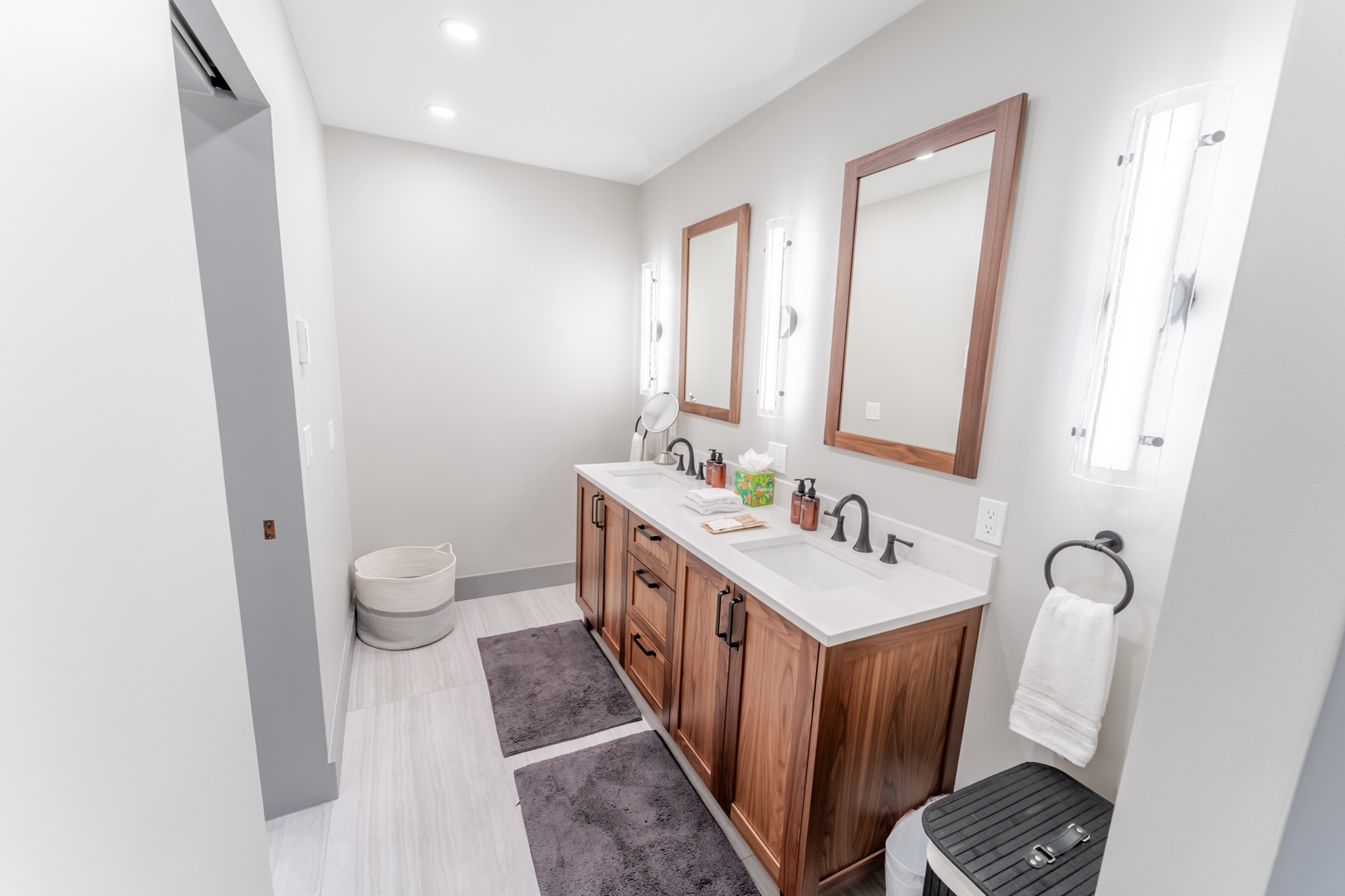 Pamper yourself in this elegant bathroom featuring dual vanities, warm wood finishes, and luxurious amenities for your morning routine.