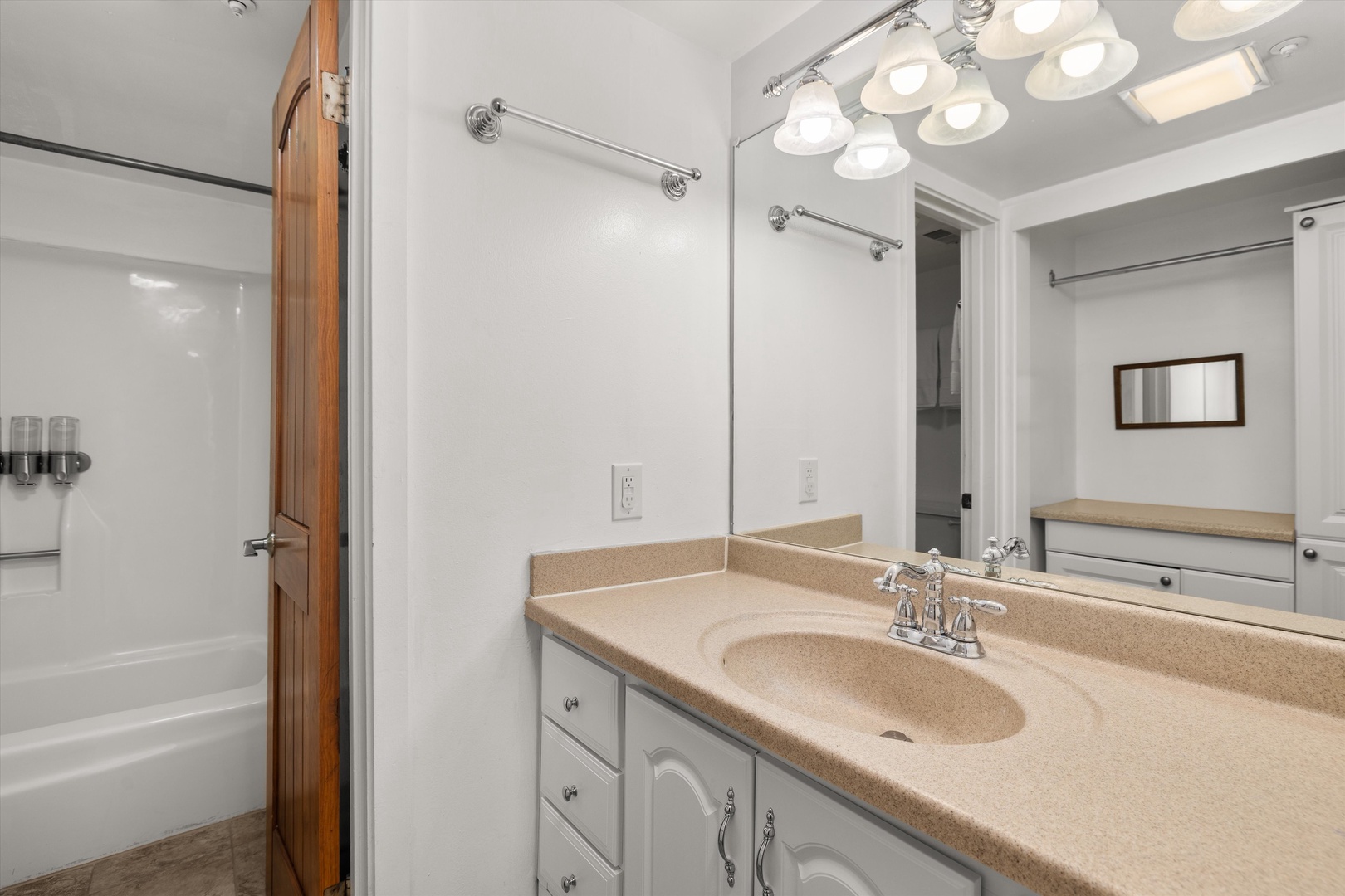 Fresh white bathroom with spacious vanity and tub-shower combo, perfect for your morning routine.