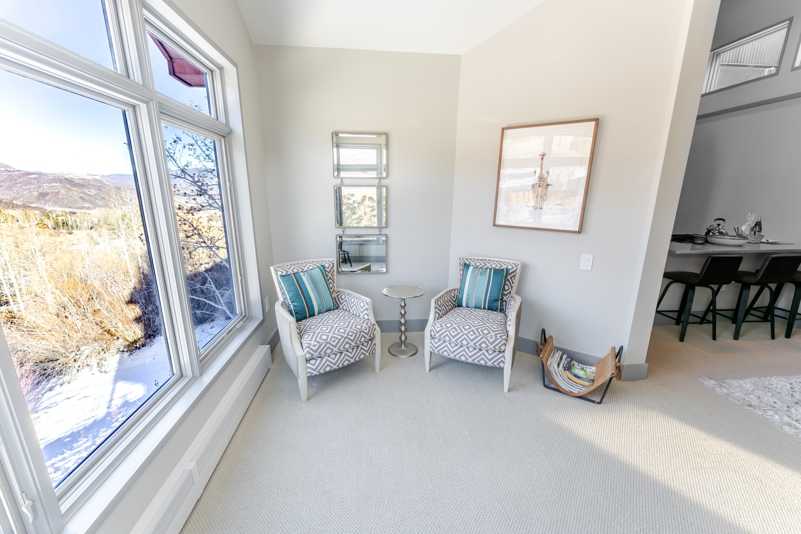 Sink into stylish comfort in your bright seating nook, where panoramic windows frame stunning natural vistas and invite warm sunlight to fill your space.