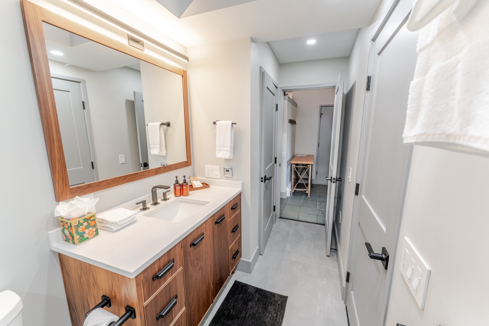 Your beautifully designed guest bathroom awaits with sleek vanity, warm wood accents, and luxurious amenities for a truly relaxing stay.