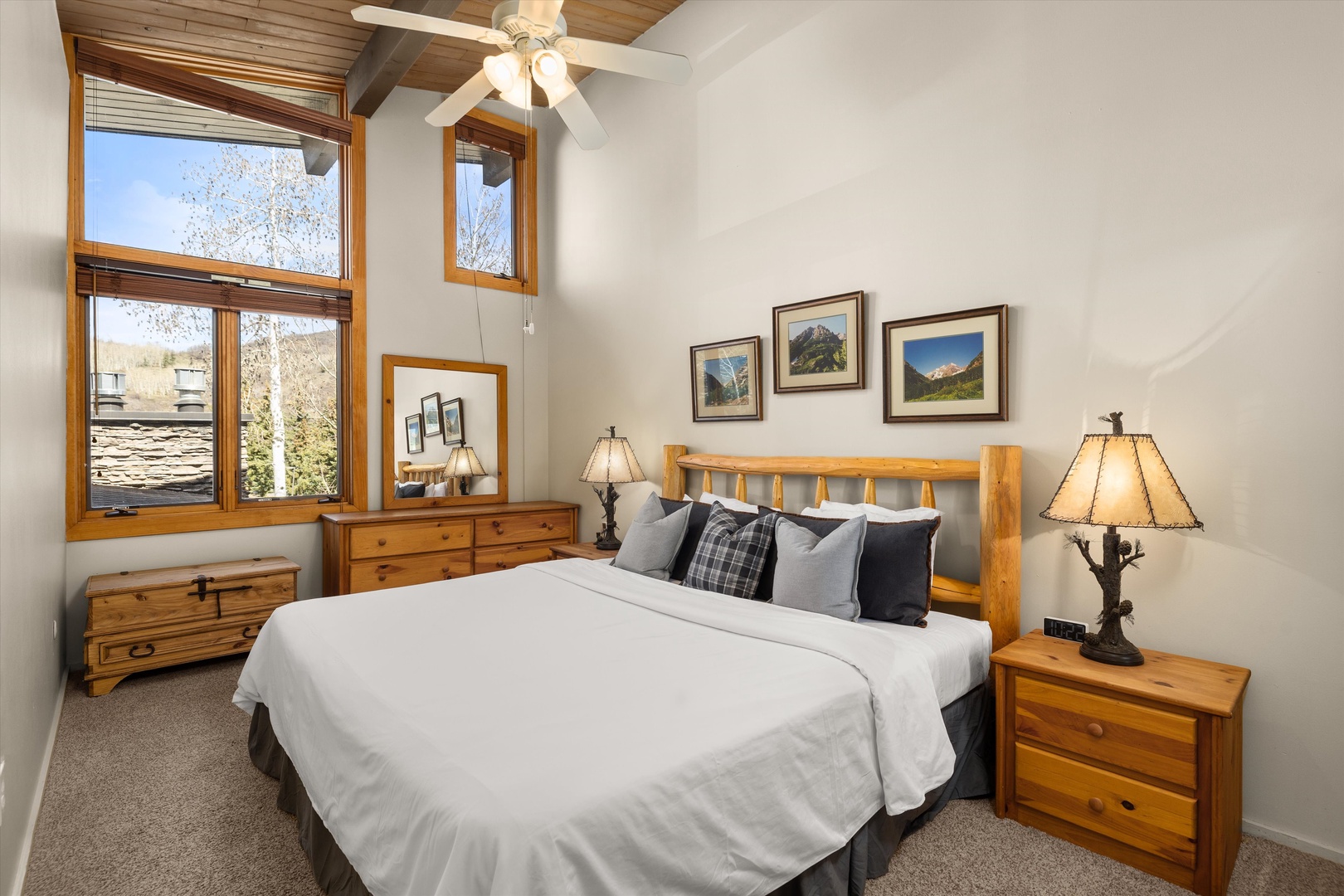 Unwind in your cozy retreat featuring rustic wood furnishings, soft linens, and mountain artwork that creates a warm, cabin-style atmosphere.