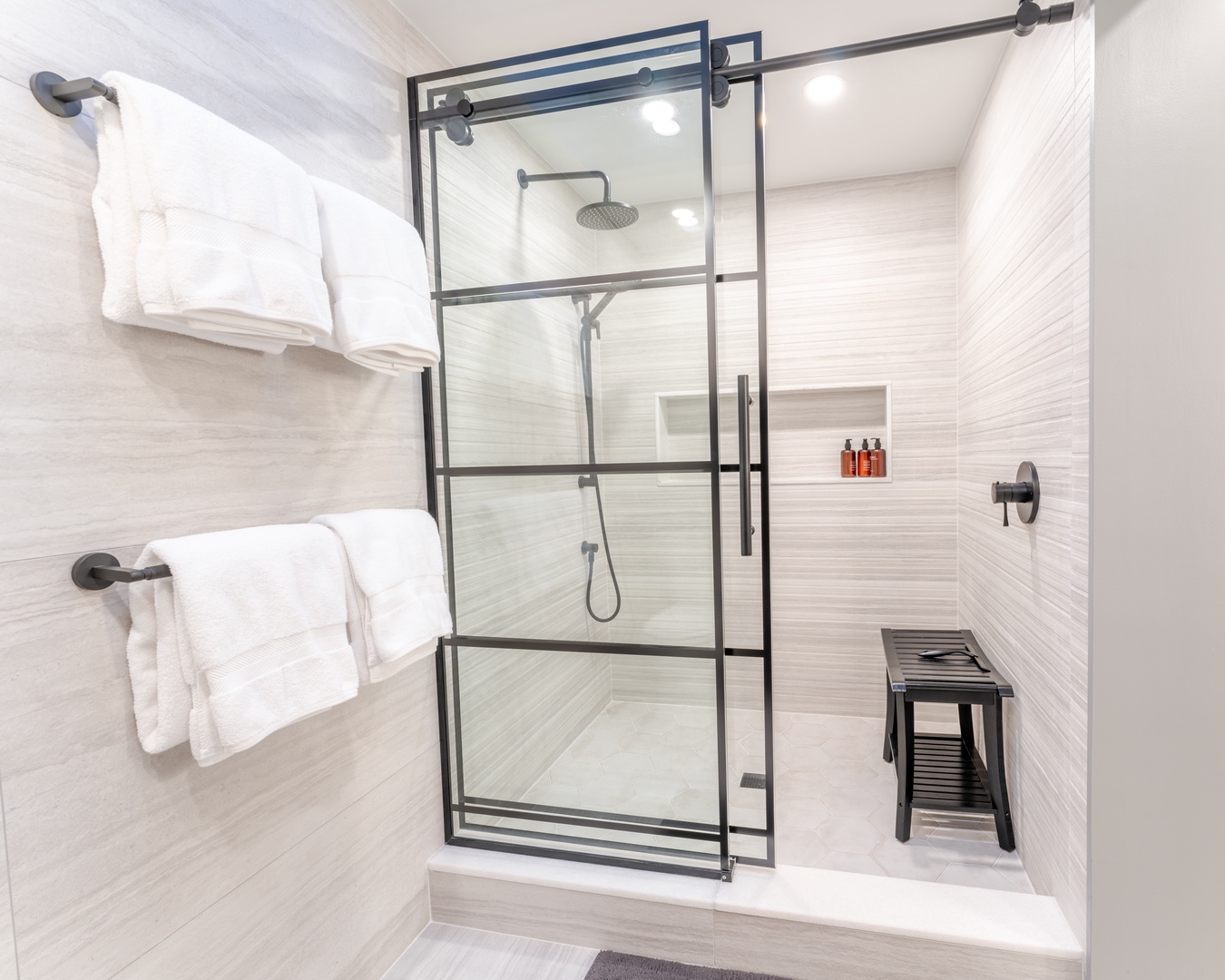 Step into your spa-like bathroom featuring a sleek glass shower with rainfall head and fluffy towels waiting for your arrival.