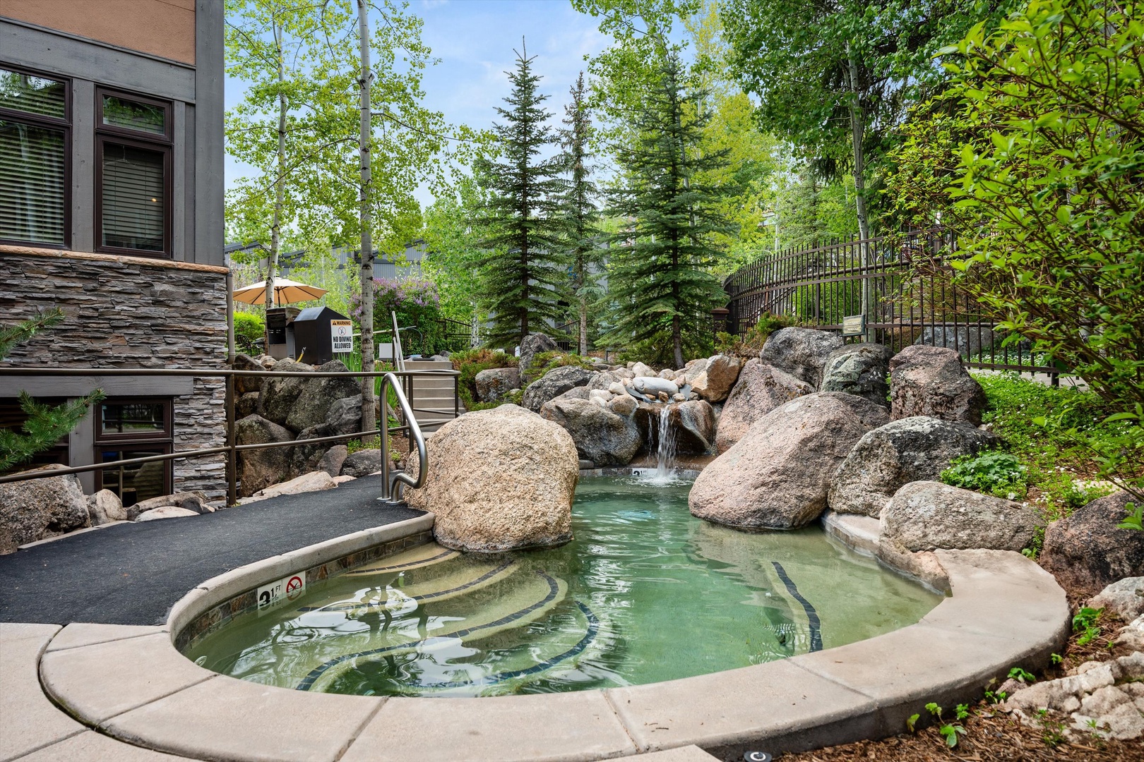 Soak your cares away in this natural rock hot tub, surrounded by towering evergreens and gentle waterfall sounds.